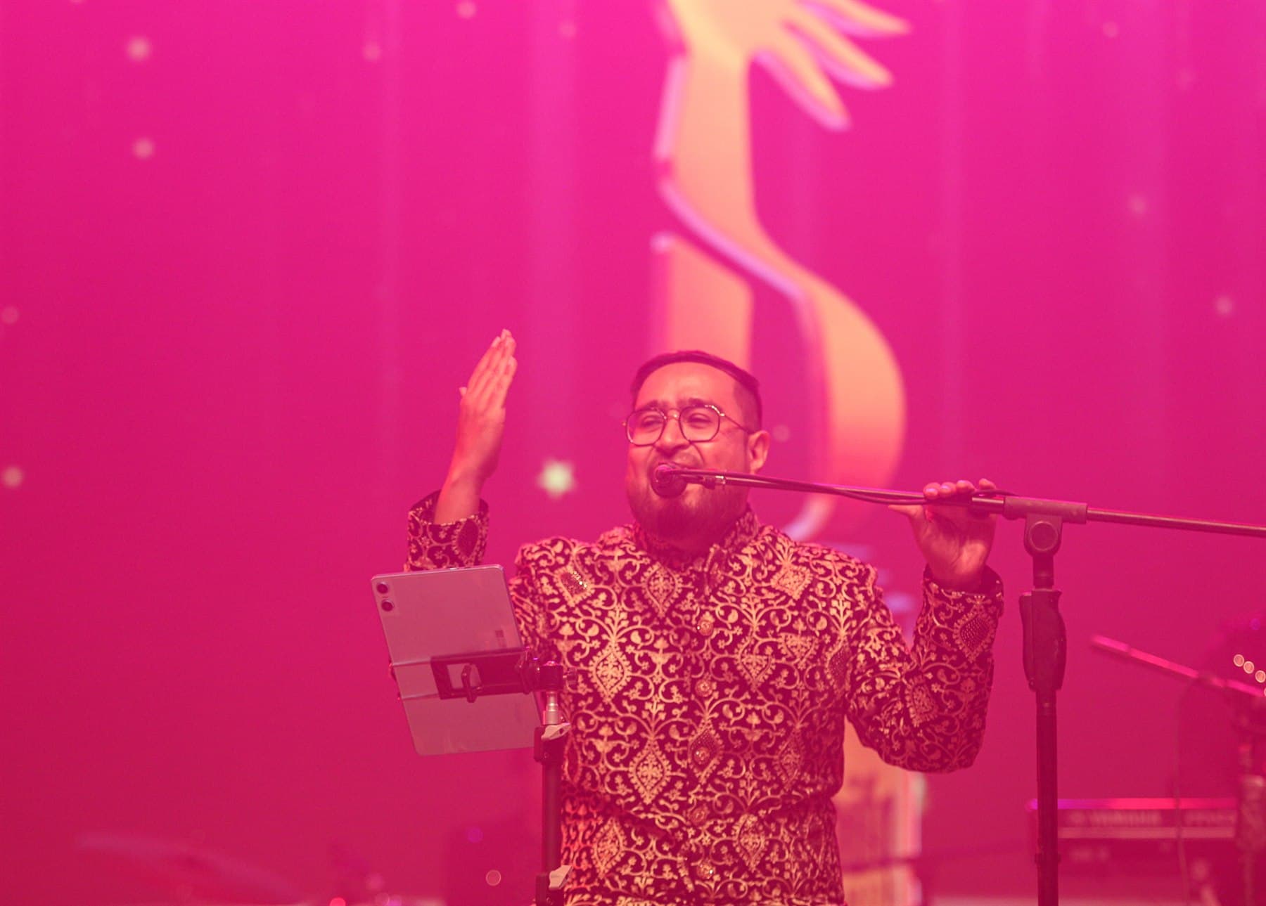 Qarar's lead vocalist performing under rose stage light